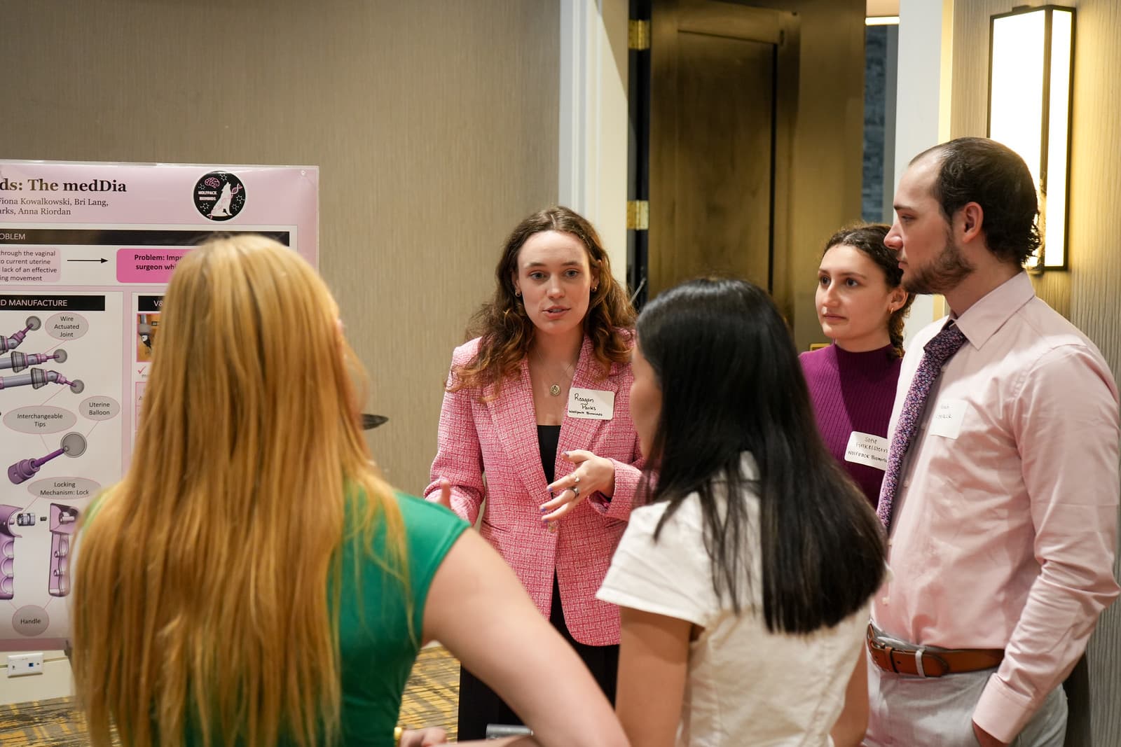 Visitors talk with a senior design team at their poster at the 2025 Design Symposium